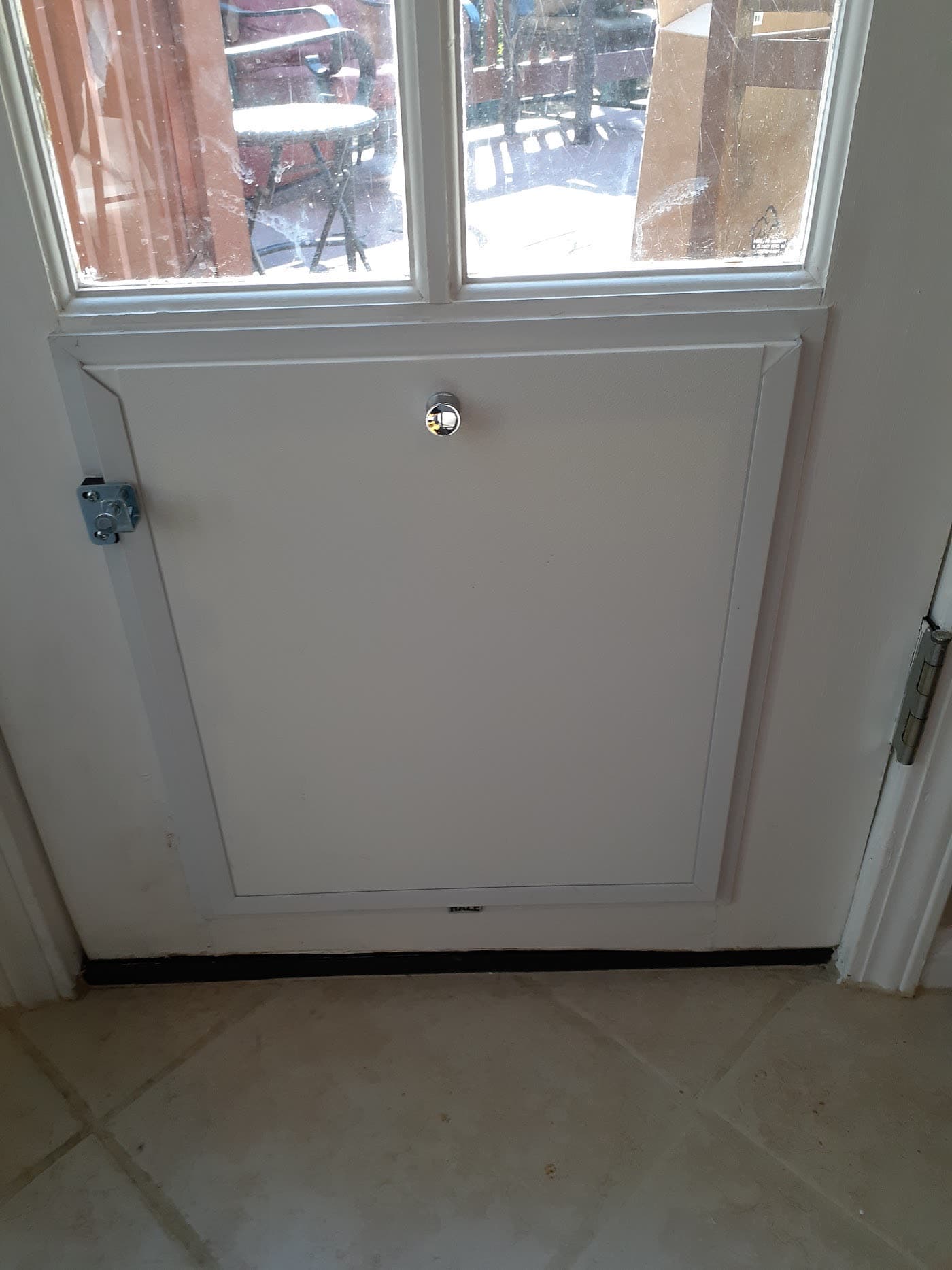 A pet door installed in a door leading out to a deck