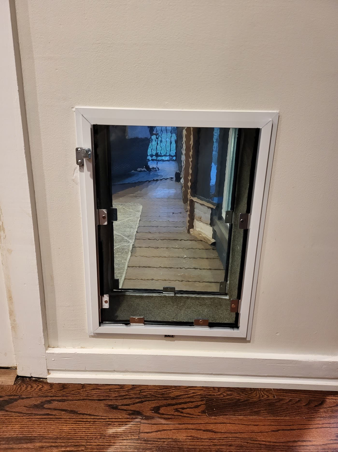 A pet door fitted into a door opening onto a porch