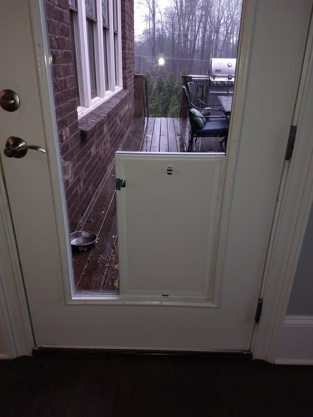A pet door installed in a full-glass door leading out to a back deck